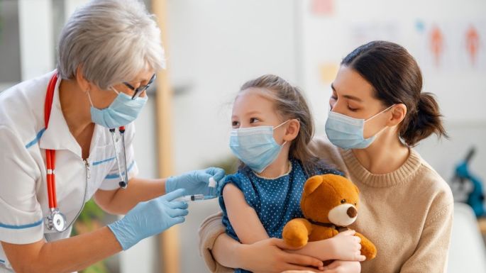 child in mom's lab getting kids COVID vaccine